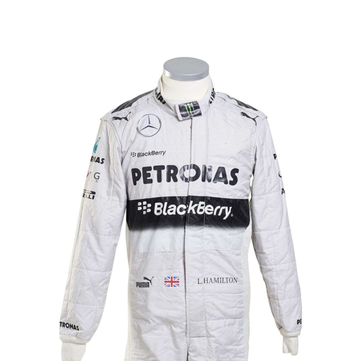 Close-up of Lewis Hamilton’s 2014 racing suit showing intricate stitching, sponsor branding, and iconic white-teal color scheme used throughout the championship.
