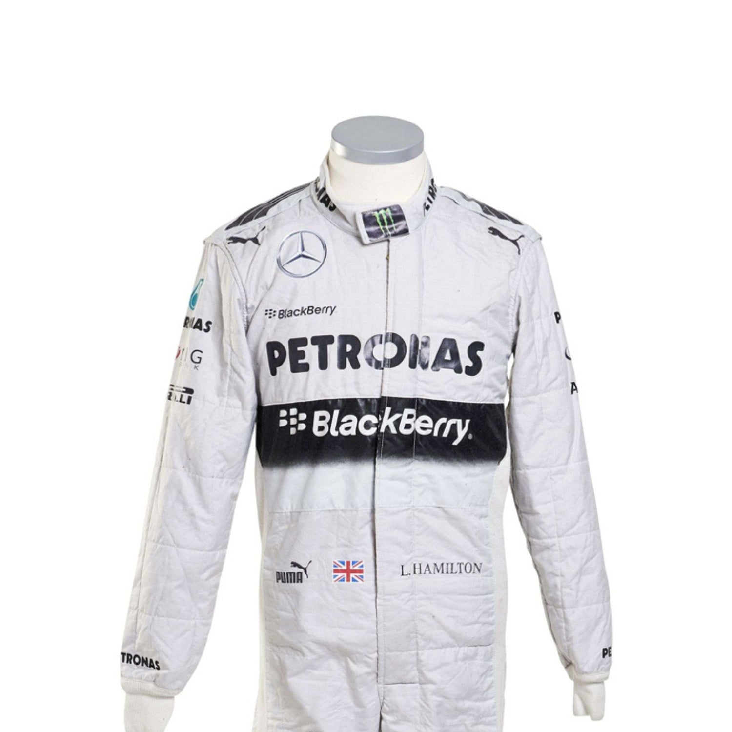 Close-up of Lewis Hamilton’s 2014 racing suit showing intricate stitching, sponsor branding, and iconic white-teal color scheme used throughout the championship.