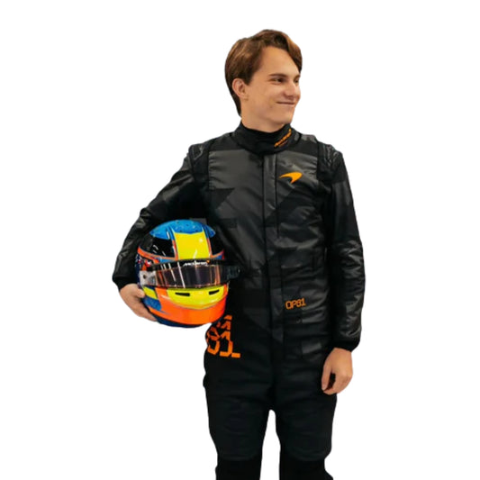 Front view of the 2025 McLaren F1 livery reveal racing costume worn by  Oscar Piastri, featuring a sleek matte black base with bold orange logos and driver initials (OP81) in neon orange.